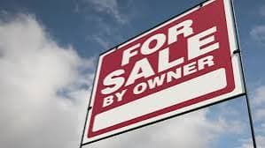 A for-sale-by-owner sign in front of a home being sold without a realtor